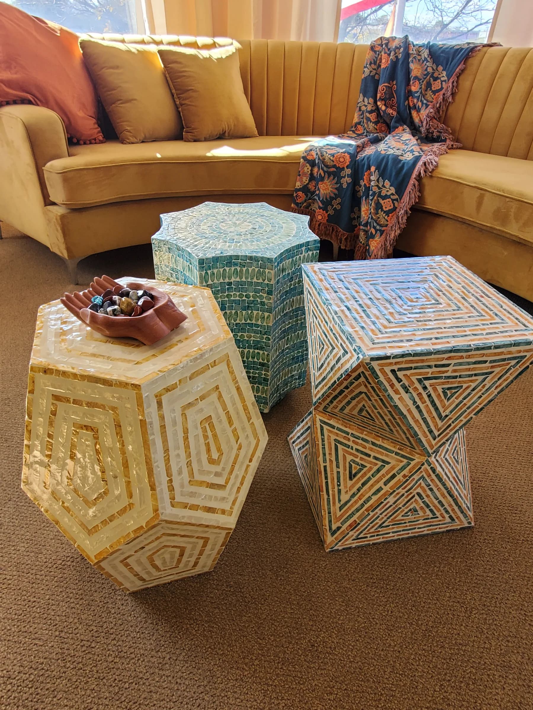 Artisan accent tables with geometric inlay, golden seating, and layered textiles — styled by Renata Glaz