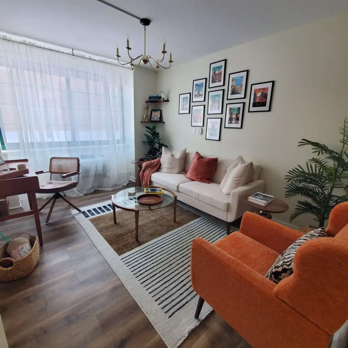 Warm, collected living room with layered seating, a gallery wall, and polished brass accents — designed by Renata Glaz