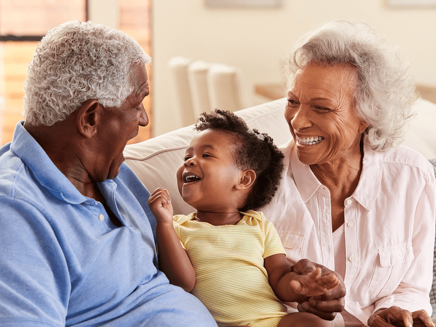 Elderly couple laughing with their grandchild