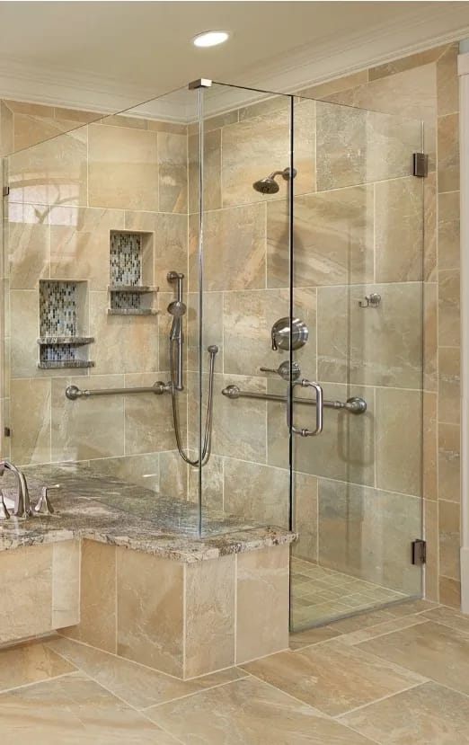 Luxury accessible walk-in shower with marble finishes, frameless glass, and integrated grab bars